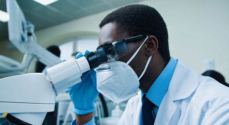 Researcher using microscope