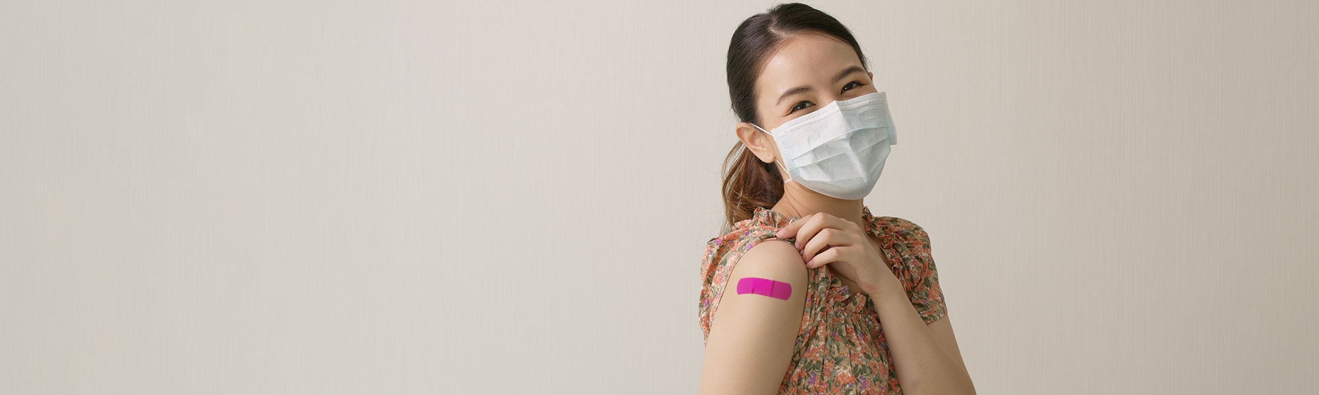Masked patient with band aid from vaccine shot