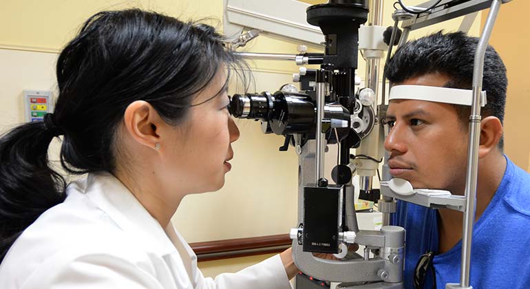 Female Ophthalmologist exams male patient with a slit lamp for corneal disease and cornea treatment