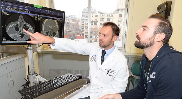 Dr. Matthew Hirsch, Facial plastic surgeon, consulting with male patient at NYEE