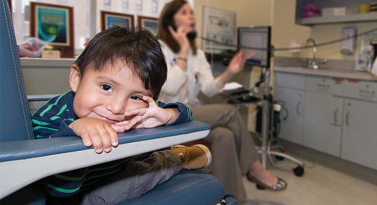 Image of small boy sitting down in doctor